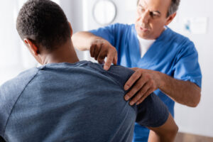Chiropractor-Glen-Burnie-MD-chiropractor-working-on-clients-shoulder